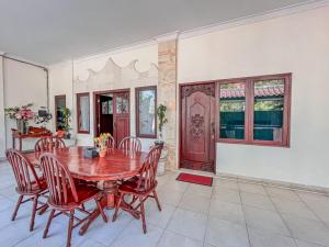 - une salle à manger avec une table et des chaises en bois dans l'établissement Villa Tentram Jimbaran by Bali Cabin, à Jimbaran