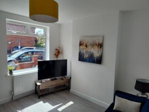 sala de estar con TV de pantalla plana en la pared en 5 Fernie ave contractor home in center of Melton Mowbray en Melton Mowbray