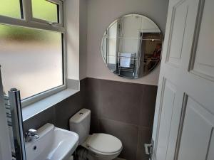 La salle de bains est pourvue de toilettes blanches et d'un miroir. dans l'établissement 5 Fernie ave contractor home in center of Melton Mowbray, à Melton Mowbray