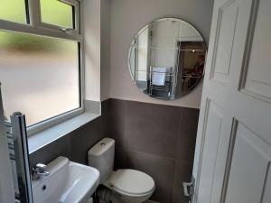 a bathroom with a white toilet and a mirror at 5 Fernie ave contractor home in center of Melton Mowbray in Melton Mowbray
