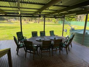 a wooden table and chairs on a deck at The Farm @ Sussex Inlet in Sussex inlet