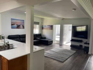 a kitchen and living room with a couch and a tv at The Farm @ Sussex Inlet in Sussex inlet