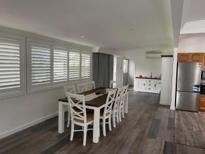a kitchen with a table and chairs and a refrigerator at The Farm @ Sussex Inlet in Sussex inlet +10 photos