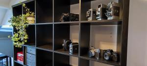 a black book shelf with two cameras on it at Fitness loft 50 m2 in Zemst