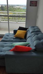 a blue couch with colorful pillows in a living room at Areatricolor in Porto Alegre