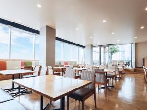 un comedor con mesas, sillas y ventanas en Lotte City Hotel Kinshicho, en Tokio