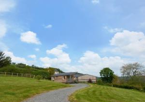 a house on a hill with a gravel road at Cwmachau - Tynant in Lower Chapel