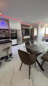 a large kitchen with a glass table and chairs at Appartement Wow in Al Hoceïma