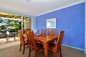 a dining room with a wooden table and chairs at Aquarius Apartment 7 in Hawks Nest