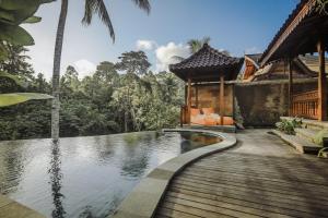 Portobello Villa Ubud في أوبود: منزل به مسبح وسطح خشبي