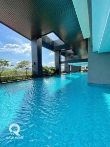 a swimming pool with blue water in front of a building at Netflix,Sauna,Jacuzzi,Karoke,Cat Friendly in Kuala Lumpur