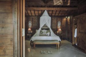 a bedroom with a bed with a canopy at Portobello Villa Ubud in Ubud