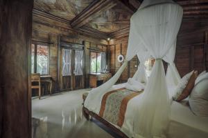 um quarto com uma cama de dossel em Portobello Villa Ubud em Ubud