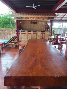 una gran mesa de madera frente a un bar en Domnak Teuk Chhou, en Kampot