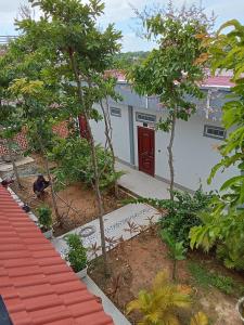 ein Haus mit einer roten Tür im Garten in der Unterkunft Domnak Teuk Chhou in Kampot