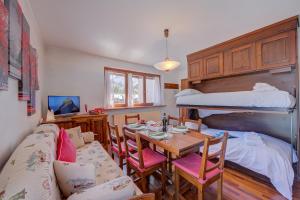 a dining room with a table and a bunk bed at Sestriere Terrace Apt Few Steps From Ski - Happy Rentals in Sestriere