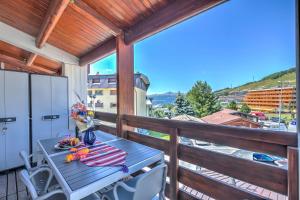 a table and chairs on a balcony with a view at Sestriere Terrace Apt Few Steps From Ski - Happy Rentals in Sestriere