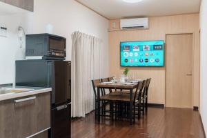 a kitchen with a table with chairs and a tv at ダイヤモンド悠 大山店 in Tokyo