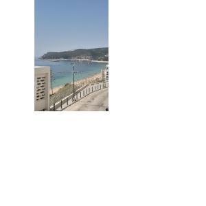 a view of the beach from the balcony of a building at Small apartment by the beach in Sesimbra