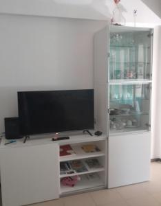 a white entertainment center with a flat screen tv at Small apartment by the beach in Sesimbra