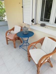 a patio with two chairs and a blue table at Sea and Stars House in Svoronata