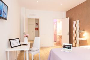 a white room with a table and a desk with two laptops at Domus Casaletto in Rome