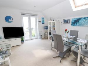 a dining room with a table and a television at Ocean Blue in Carbis Bay