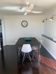 a dining room table with a clock on the wall at Spacious family home with Pool in Ascot in Brisbane