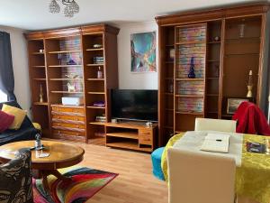 a living room with a tv and a couch and a table at Dundee City Waterfront, 2 Bedroom 2 Bathroom Apartment - Parking and WIFI, short walk to V and A, Bus & Train Stations in Dundee