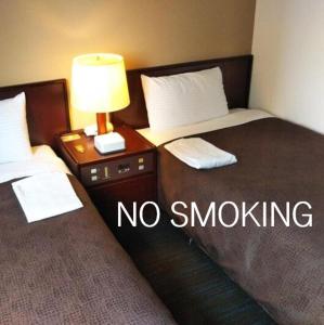 a hotel room with two beds with no smoking sign at Select Inn Hamamatsu Ekimae in Hamamatsu