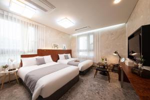 ソウルにあるHotel DMのベッド2台と薄型テレビ付きのホテルの部屋 +26枚の写真