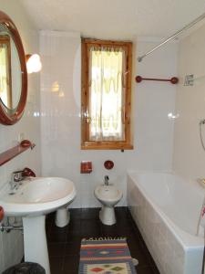 a bathroom with a sink and a tub and a toilet at Monolocale Alberti - Prato del Sogno in Madonna di Campiglio