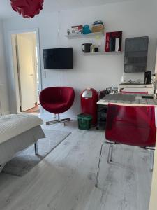 sala de estar con silla roja y mesa en Løkke-bo, en Løkken