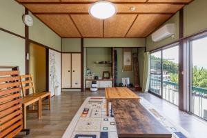un soggiorno con tavolo e una grande finestra di 和歌浦Poseidon家族団体専用個室 a Wakayama