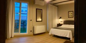 a bedroom with a bed and a large window at Hotel Tharsis in Cazorla