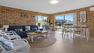 a living room with a couch and a table and chairs at unit 6 53 Ocean Drive, Merimbula in Merimbula