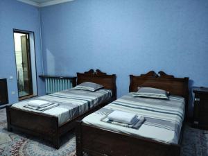 2 Betten in einem Zimmer mit blauen Wänden in der Unterkunft REAL Tashkent in Taschkent