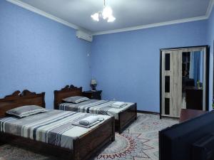 two beds in a room with blue walls at REAL Tashkent in Tashkent