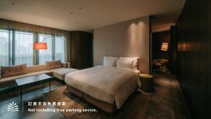 a hotel room with a bed and a couch at Hotel Royal Beitou in Taipei