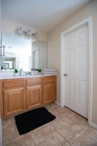 a bathroom with a sink and a mirror at Large 3BR King Suite Moments Away From Strip in Las Vegas