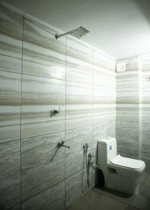 a bathroom with a toilet and a glass shower at Salalah Enclave - 3 AC Bedroom House at Vytilla, Kochi in Cochin +15 photos