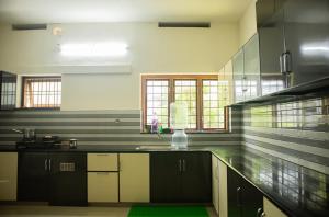 a kitchen with a sink and a counter top at Salalah Enclave - 3 AC Bedroom House at Vytilla, Kochi in Cochin