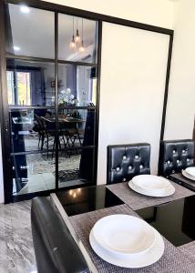 Modern Style Village House في كوتشينغ: غرفة طعام مع طاولتين وكراسي عليها لوحات