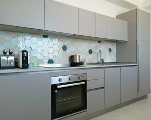a kitchen with white cabinets and a stove top oven at Casa Mylai in Castelmola