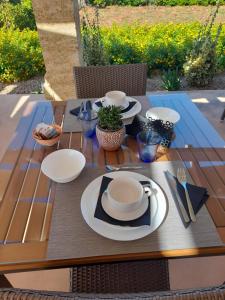 a wooden table with plates and utensils on it at B&B MARRELLA in Capilungo