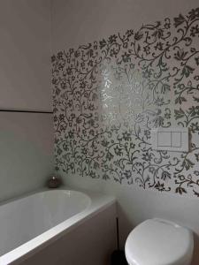 een badkamer met een bad, een toilet en een bad bij Casa Capelute in Udine