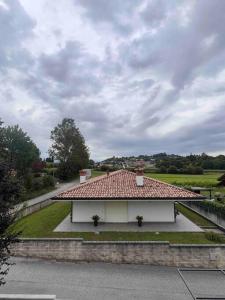 a white house with a red roof on a street at Casa Capelute in Udine