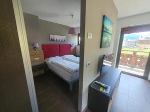 um pequeno quarto com uma cama e uma janela em VERDELAGO Appartamenti e CASA CRY em Livigno