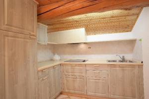 een keuken met houten kasten en een wastafel bij VERDELAGO Appartamenti e CASA CRY in Livigno