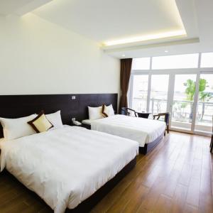 a hotel room with two beds and a large window at J&C HOTEL in Bắc Ninh